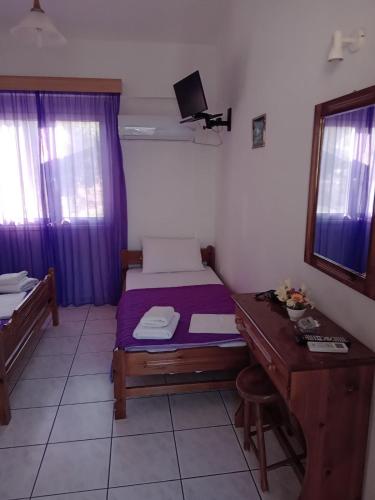a small bedroom with a bed and a desk at The Captain in Elafonisos