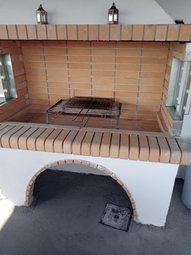 a patio with a brick wall with two lights at The Captain in Elafonisos