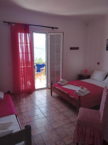a bedroom with two beds and a door to a patio at The Captain in Elafonisos