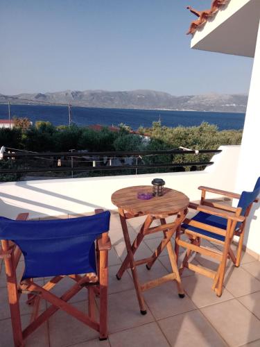 a table and chairs on a balcony with a view of the ocean at The Captain in Elafonisos