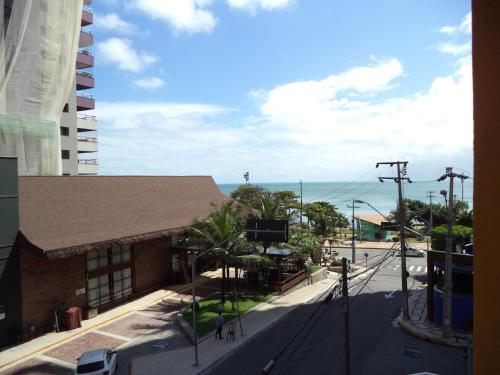 a building on a street with the ocean in the background at Netuno Beach Hotel in Fortaleza