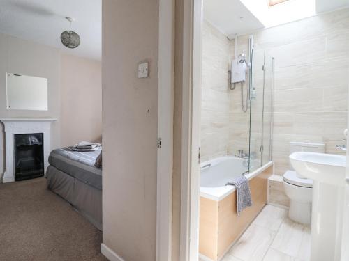 a bathroom with a tub and a toilet and a sink at Haulfryn in Bangor