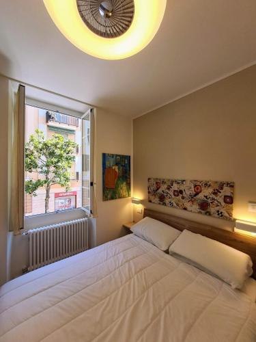 Un dormitorio con una gran cama blanca y una ventana en Nido d'amore a Ventimiglia, en Ventimiglia