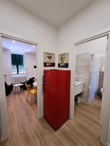 Una habitación con un refrigerador rojo y un comedor. en Casa Vanda, en Ventimiglia