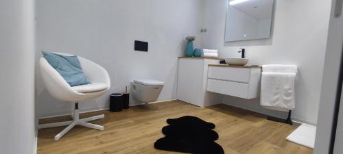 een badkamer met een stoel, een wastafel en een bureau bij Casa de Silvares in Celorico de Basto