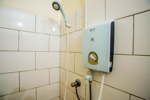 een douche in een badkamer met een lampje aan de muur bij The Secret Garden Hotel Moshi in Moshi