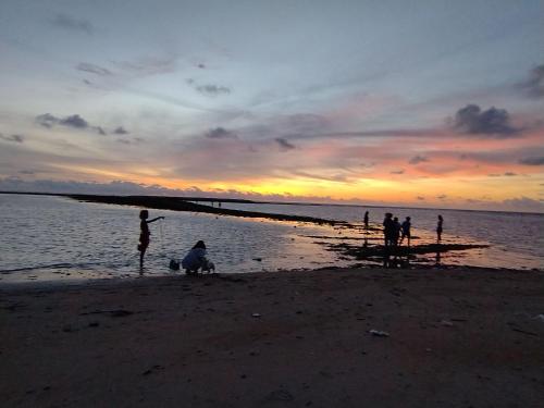 a group of people on the beach at sunset at STAYHERE@AIRPORT SERVICE APARTMENT in Ban Bo Han