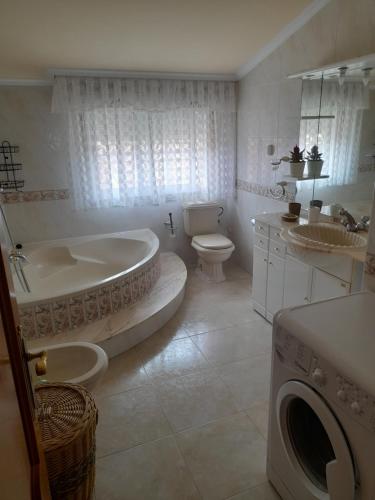 a bathroom with a tub and a toilet and a sink at Atico augaboa in Cangas de Morrazo