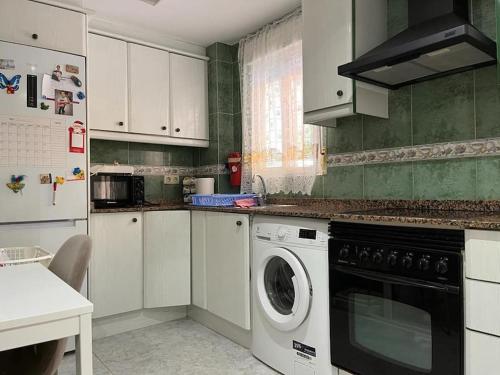 a kitchen with a washer and dryer in it at Casa Denise in Playa de Gandia