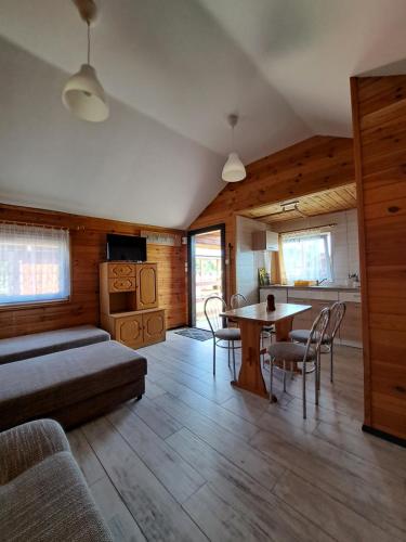 sala de estar con cama, mesa y sillas en Domki letniskowe GOSIA, en Żarnowska