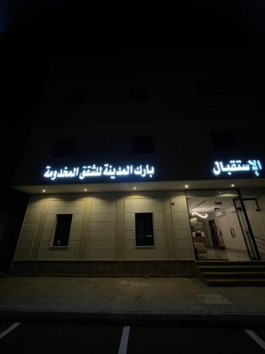 un cartello sul lato di un edificio di notte di بارك المدينة للشقق المخدومة a Medina