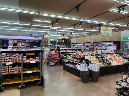 a grocery store aisle with a lot of produce at Inari-Home in Kyoto