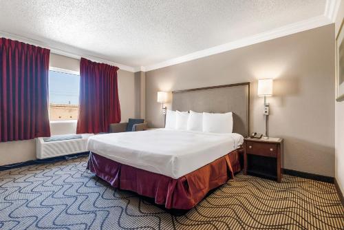 ein Hotelzimmer mit einem großen Bett und einem Fenster in der Unterkunft Jack London Inn in Oakland