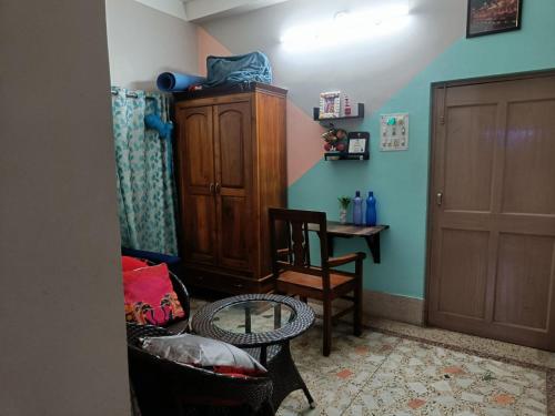 a room with a cabinet and chairs and a table at Terrace garden & Unique 1 bedroom AC rental unit in Haldia in Haldia