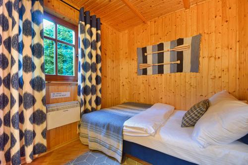 a bedroom with a bed in a wooden cabin at Domki Pod Brzozami in Dźwirzyno