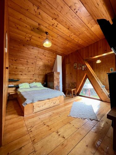 - une chambre avec un lit dans une cabane en bois dans l'établissement Mountain Getaway Cabin, à Cheia