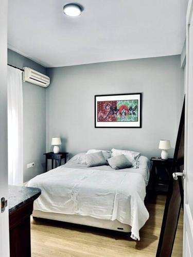 1 dormitorio con 1 cama blanca y 2 almohadas en Piso bonito y tranquilo en Plaza de la Magdalena, en Sevilla