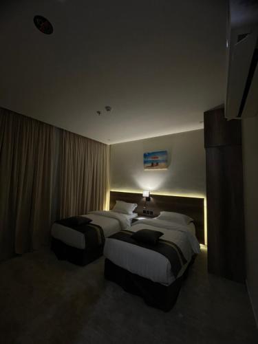 a hotel room with two beds in a room at بارك المدينة للشقق المخدومة in Al Madinah