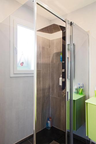 une douche avec une porte vitrée dans une salle de bain dans l'établissement Belle Villa moderne avec piscine et jardin, à Solliès-Pont