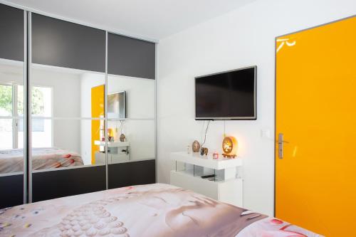 Schlafzimmer mit einem Bett und einem Flachbild-TV in der Unterkunft Belle Villa moderne avec piscine et jardin in Solliès-Pont