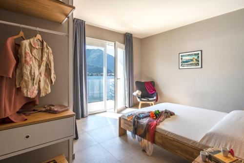 - une chambre avec un lit, une fenêtre et une chaise dans l'établissement d'Ocalée Holiday Experience lago d'Orta, à Omegna