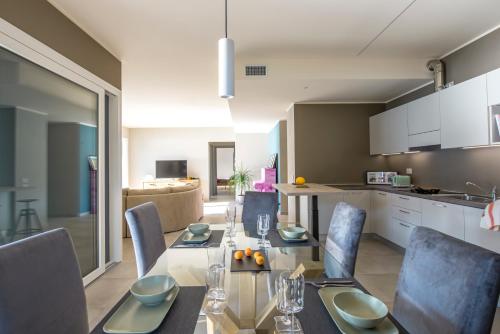 a dining room with a table and chairs and a kitchen at d'Ocalée Holiday Experience lago d'Orta in Omegna