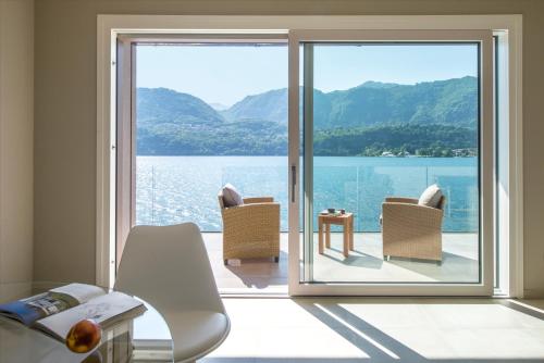 a room with a large glass door with a view of the water at d'Ocalée Holiday Experience lago d'Orta in Omegna