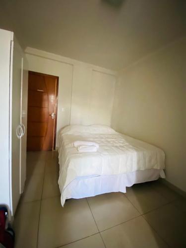 a bedroom with a bed in a room with a door at Hotel Santorine Prime - Itabira in Itabira