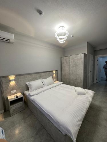 Un dormitorio con una cama grande y una lámpara de araña. en ReveL HoteL, en Tashkent