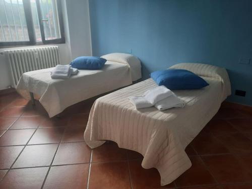 2 bedden met blauwe kussens in een kamer bij GROSSI 19 in Rho