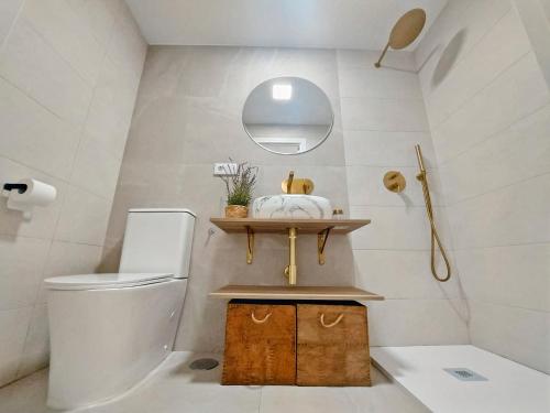 een badkamer met een toilet, een wastafel en een spiegel bij Barrameda 19 in Sanlúcar de Barrameda