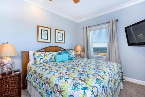 a bedroom with a bed and a flat screen tv at RSR3C - Sunsets Galore in Rodanthe