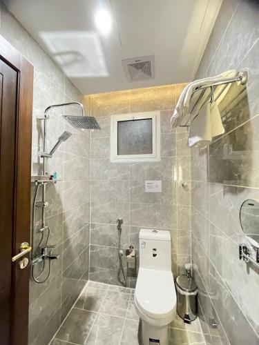 a bathroom with a toilet and a shower at بارك المدينة للشقق المخدومة in Al Madinah
