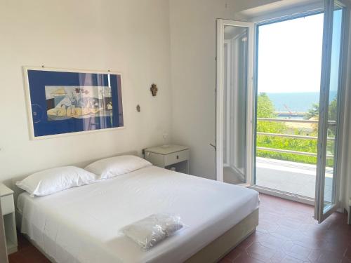 - une chambre avec un lit blanc et une grande fenêtre dans l'établissement terrazza vista mare, giardino, parcheggio, wi fi, à Numana