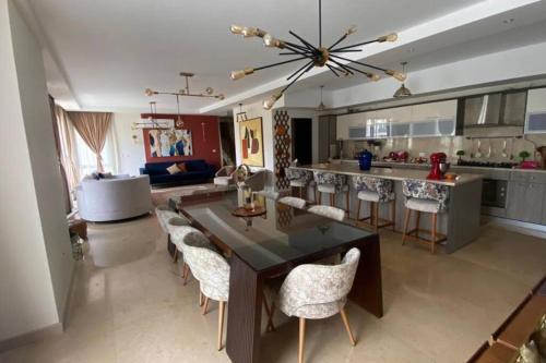 uma grande cozinha com mesa de jantar e cadeiras em luxurious 2bed's duplex sheikh zayed beverly hills em Sheikh Zayed