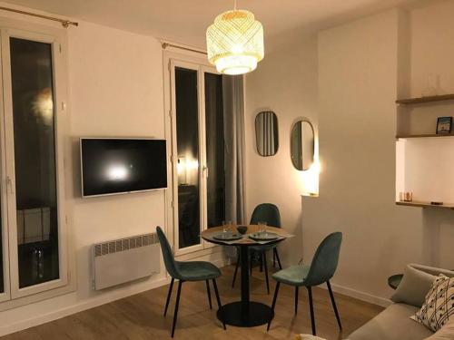 - un salon avec une table, des chaises et une télévision dans l'établissement Appartement Vieux-Port/ 2 min du métro Estrangin, à Marseille