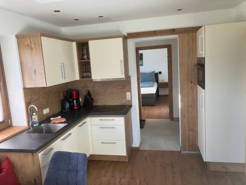 a kitchen with white cabinets and a sink at Ramseiderhof in Saalfelden am Steinernen Meer