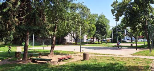 a park with benches and trees and a person riding a bike at Apartman Živković in Leskovac