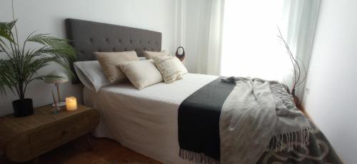 1 dormitorio con cama con almohadas y ventana en Apartamento en Moaña, en Moaña