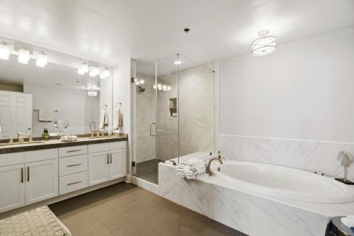 巴拿马城海滩Luxury 3BD 3BA plus Bunks Beach Condo! Ocean Views! Free Beach Chairs & Umbrella Service! by Dolce Vita Getaways PCB的带浴缸和淋浴的白色浴室