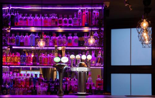 a bar with a bunch of bottles of alcohol at East Beach Hotel in Eastbourne