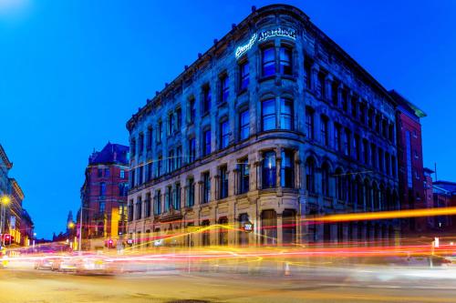 a building on a city street at night at Roomzzz Manchester City in Manchester