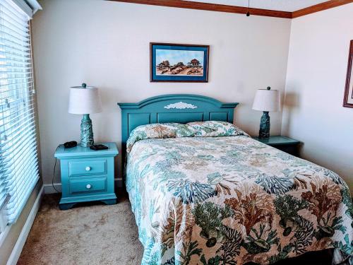 a bedroom with a blue bed and two night stands at SS9 - Raynorshine in Kill Devil Hills