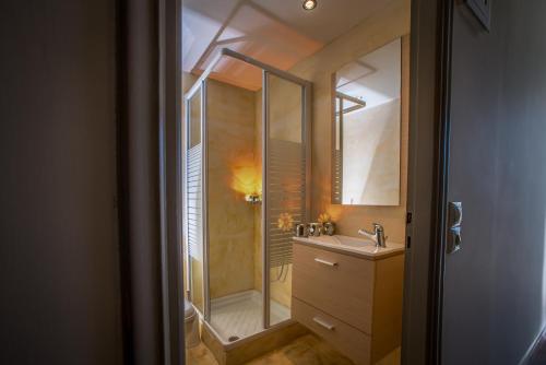 uma casa de banho com um chuveiro e um lavatório. em Natalie Hotel em Laganas