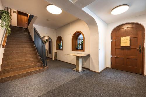 a hallway with a staircase and a wooden door at Lake and Cityhotel Edelweiss - self Check in in Zell am See