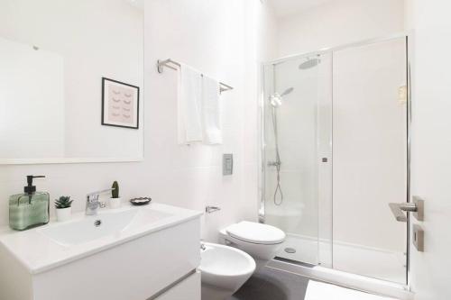 a white bathroom with a toilet and a shower at Casa Bia in Lagos