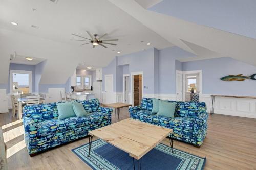 a living room with two couches and a table at Sunrises to Sunsets in Nags Head