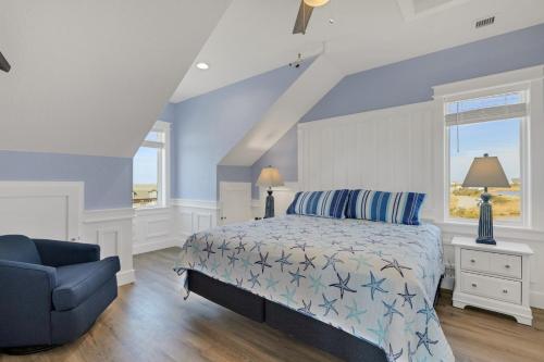 a blue bedroom with a bed and a blue chair at Sunrises to Sunsets in Nags Head