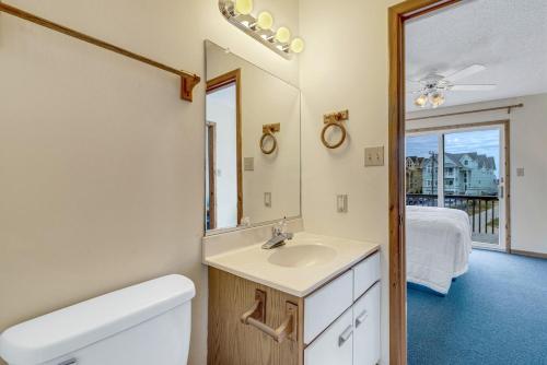 a bathroom with a sink and a mirror at 1904 - The Yancey Cottage MP 9,5 in Kill Devil Hills