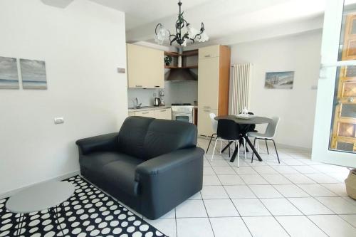 ein Wohnzimmer mit einem schwarzen Sofa und einem Tisch in der Unterkunft Casa Lety con giardino, aria condizionata e wifi in Rimini